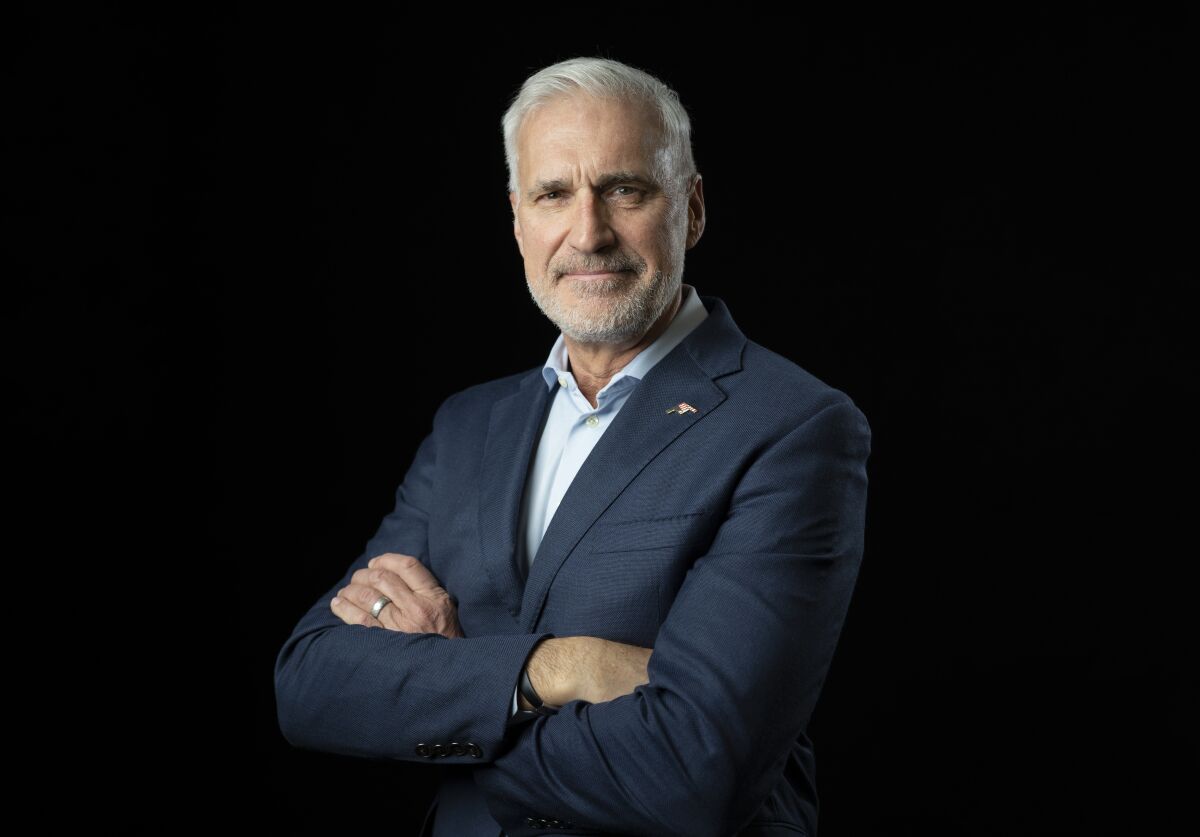 Doug Young, an executive with Northrop Grumman, stands in front of a black background.