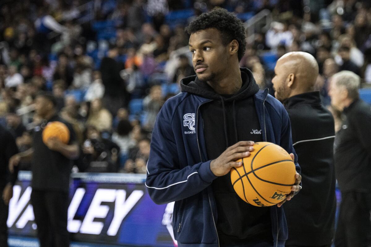 Bronny James holds a basketball before a game