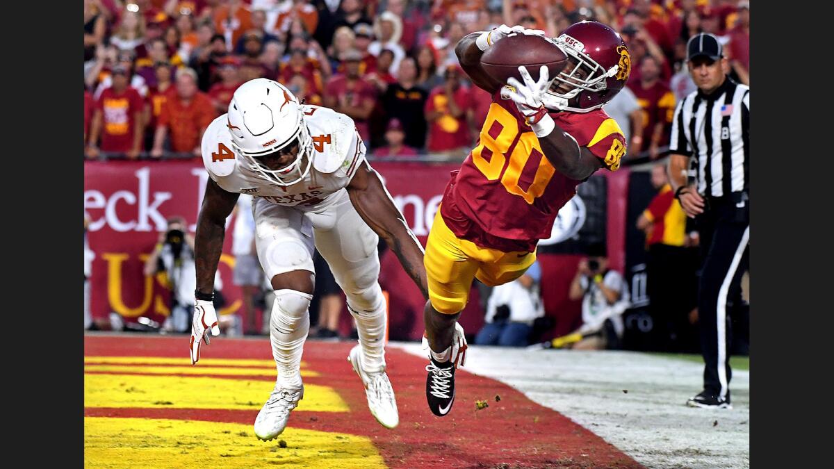 USC receiver Deontay Burnett catches a touchdown pass in front of Texas defensive back DeShon Elliott during the second quarter of a game at the Coliseum.