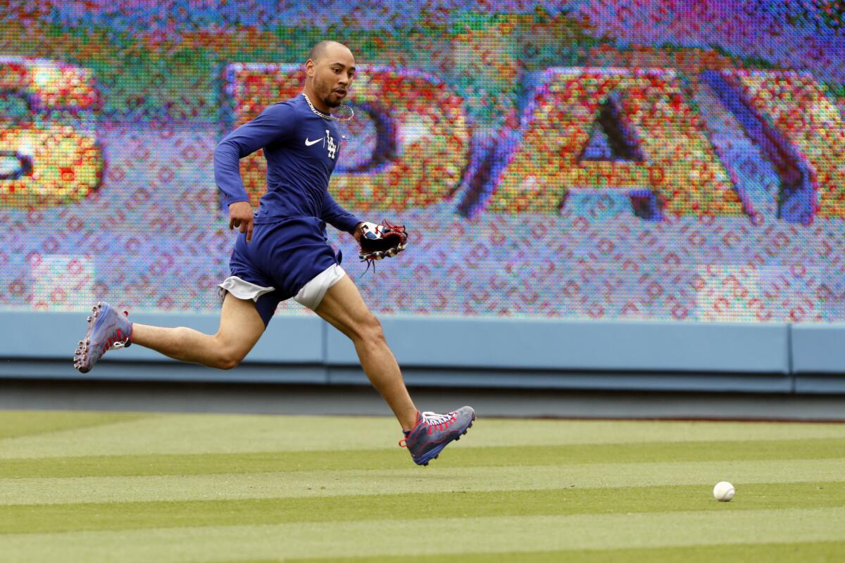 Los Angeles Dodgers' Mookie Betts runs down a ball during a workout before a baseball game.