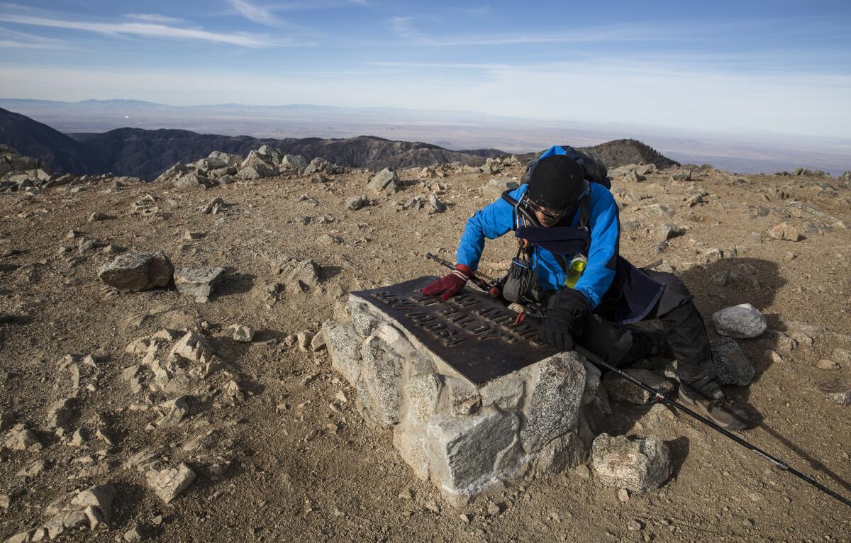 Sam Kim arrives at a plaque atop Mt. Baldy.