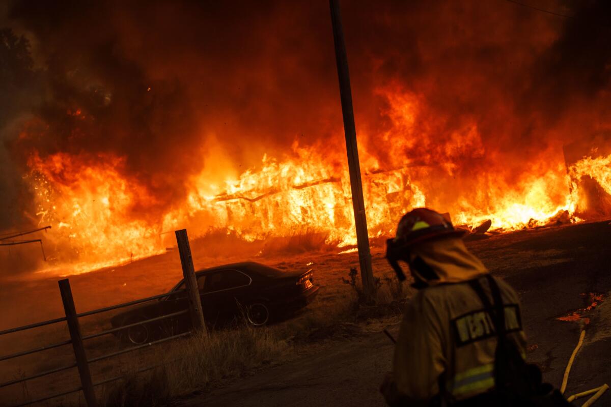 A barn is engulfed in flames as the River fire spreads with the wind near Hendricks Road in Lakeport, Calif.