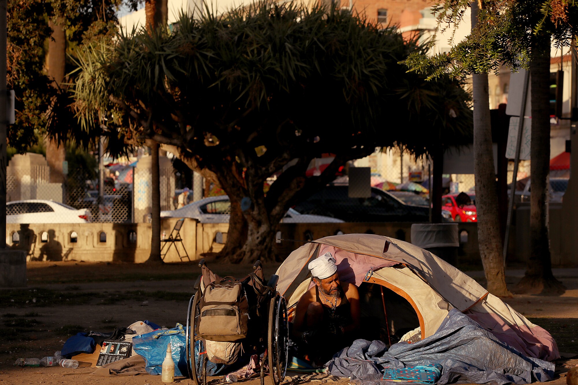 A homeless man named John sorts through his belongings before leaving MacArthur Park in Los Angeles 