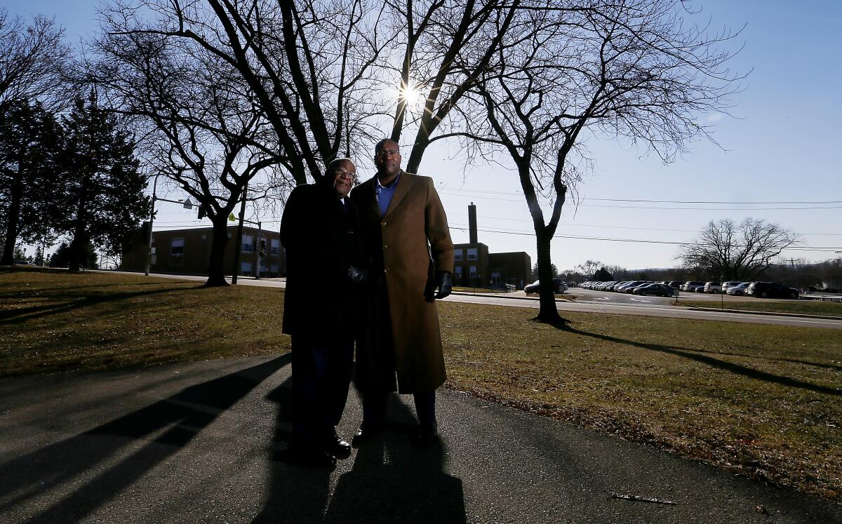 Jerome Greer, left, and son Jason stand near Irving Elementary in Dubuque, Iowa.