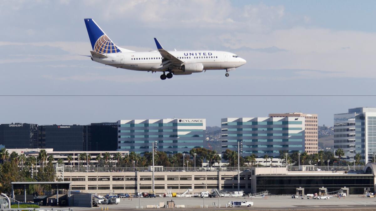 A plane flies over the 405 Freeway as it approaches the runway at John Wayne Airport on October 20, 2015.