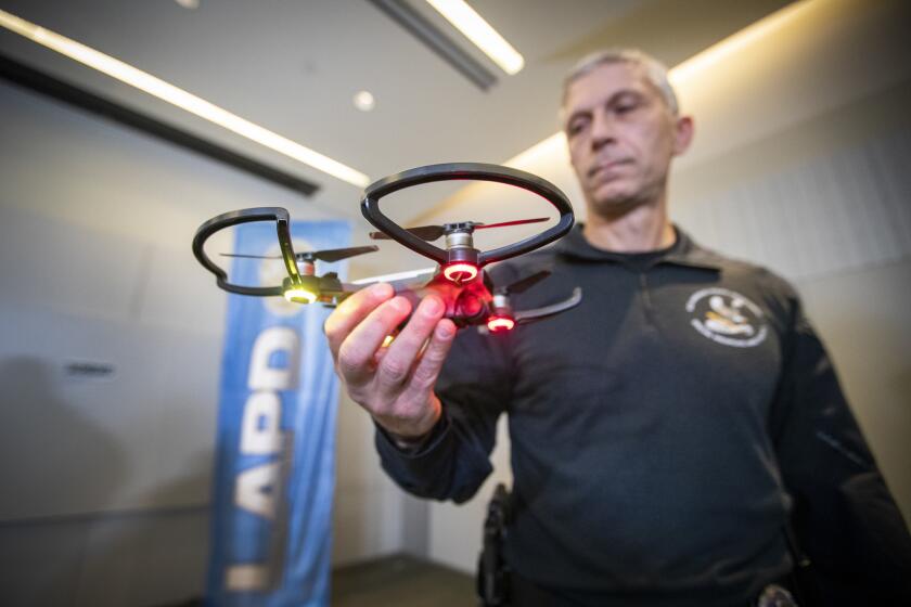 LOS ANGELES, CALIF. -- TUESDAY, JANUARY 15, 2019: LAPD SWAT officer and drone operator Tom Chinappi holds the smallest model of the department's four drones after LAPD Chief of police Michel Moore spoke about the LAPD's first use of a drone during a police standoff situation at a press conference at LAPD Headquarters in Los Angeles, Calif., on Jan. 15, 2019. Earlier this month, the LAPD deployed a drone for the first time on a suspect as part of a pilot program that was opposed by residents and activists who saw it as a first step towards an Orwellian spy state. At a press conference Tuesday, LAPD officials gave details about the drone operation, which occurred against a barricaded robbery suspect on Jan. 9. (Allen J. Schaben / Los Angeles Times)