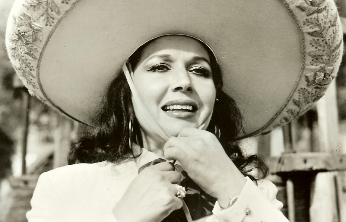 Flor Silvestre cinches up her sombrero in a movie scene