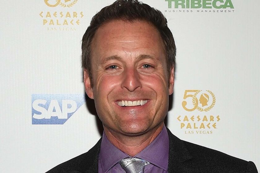 Chris Harrison smiling in a suit
