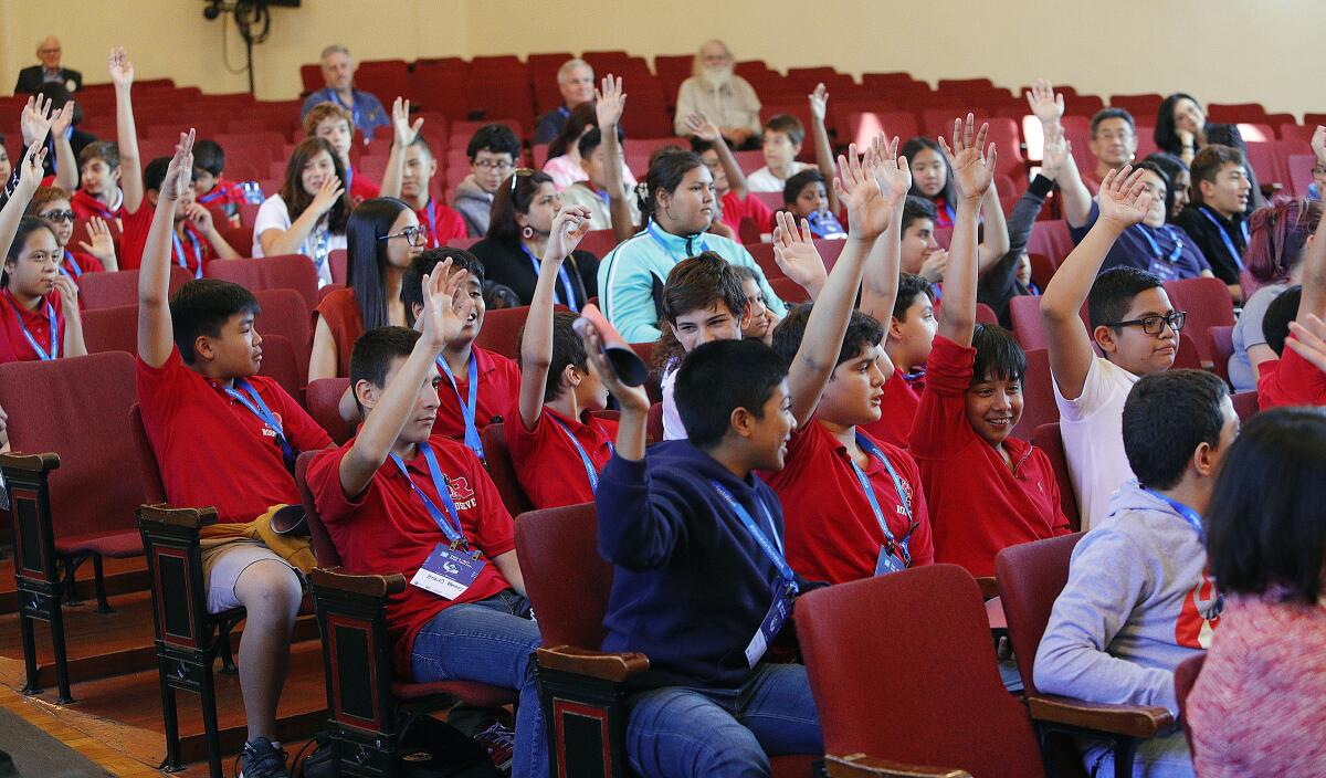 Students at Roosevelt Middle School raise their hands after being asked if any of them has done any computer programming during a panel discussion about artificial intelligence held at the campus on Sept. 16 as part of Glendale Tech Week. 
