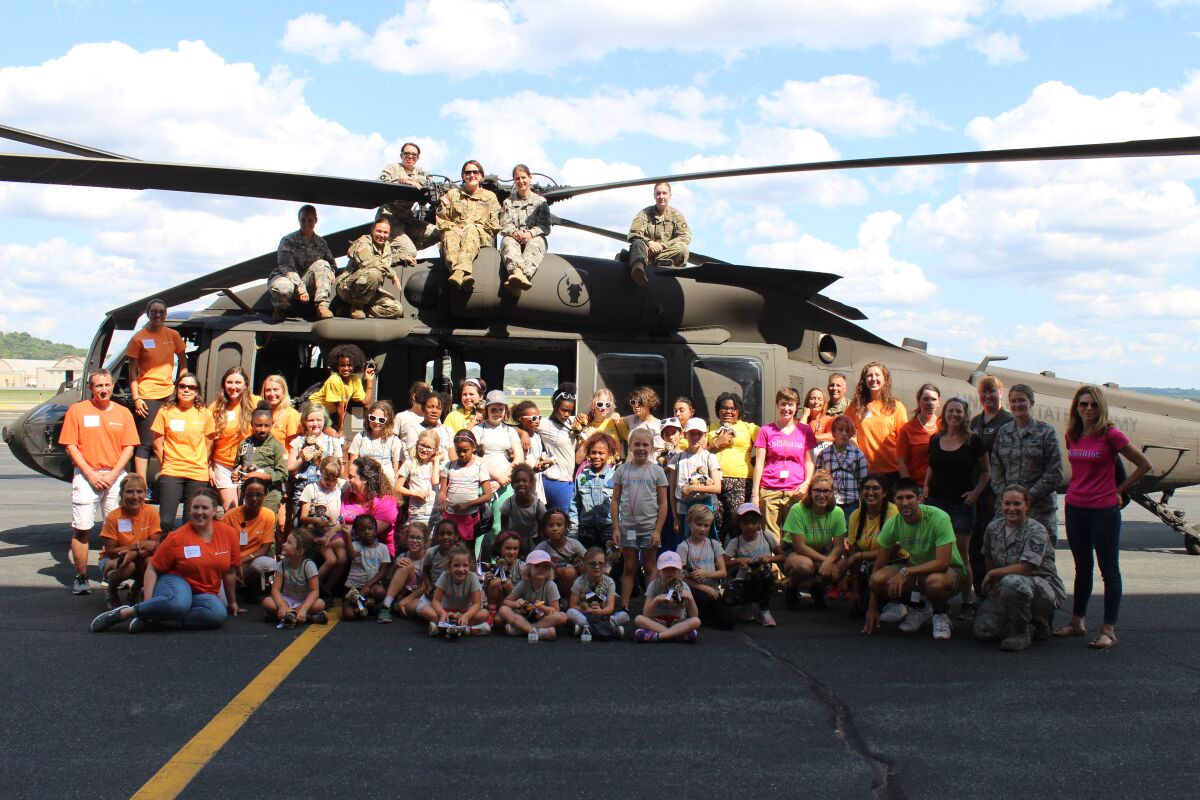 Project Scientist girls join pilots, engineers and mechanics from the Minnesota Air National Guard and Collins Aerospace for a photo during a summer exhibition last year in St. Paul, Minn.