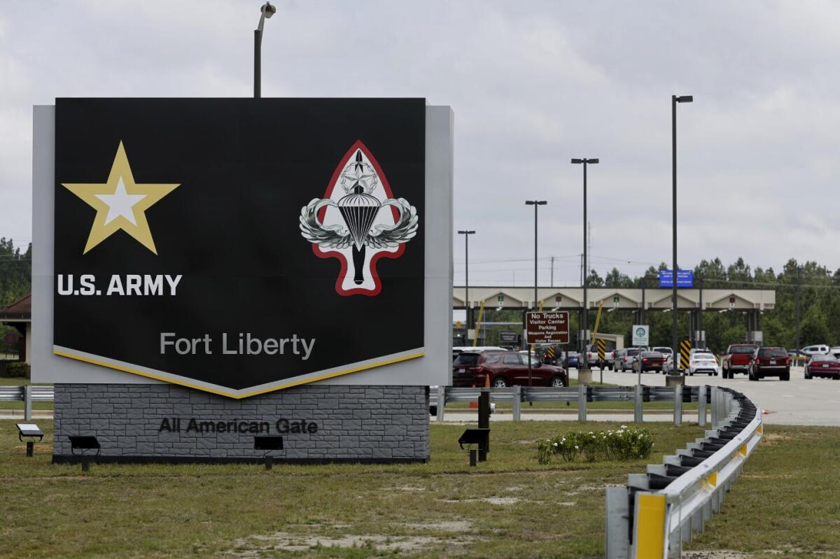 A large entrance sign with U.S. Army symbols reads "Fort Liberty" and "All American Gate."