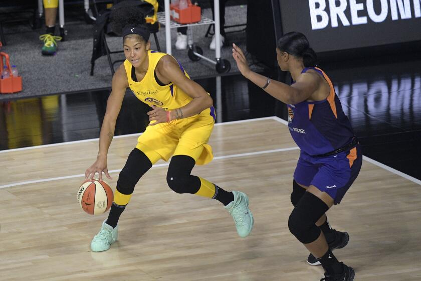Los Angeles Sparks forward Candace Parker, left, sets up a shot in front of Phoenix Mercury center Kia Vaughn during the first half of a WNBA basketball game, Saturday, July 25, 2020, in Bradenton, Fla. (AP Photo/Phelan M. Ebenhack)