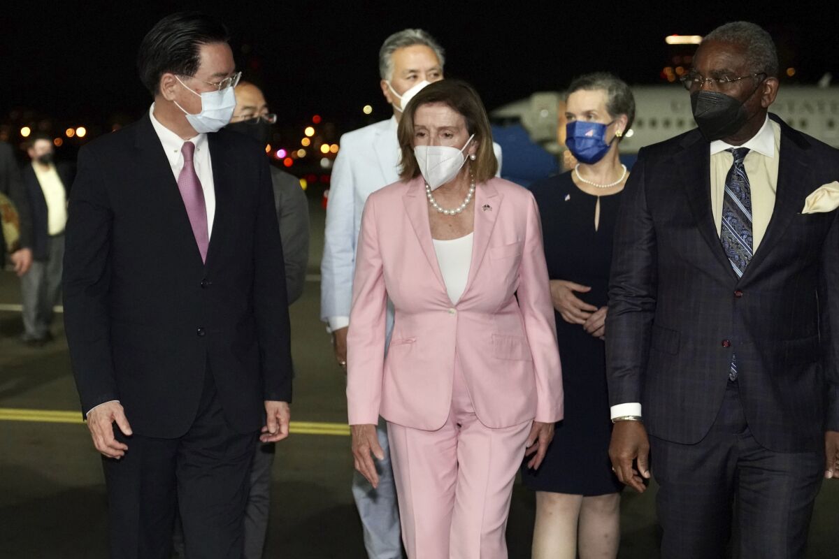 Nancy Pelosi and others walking on an airport tarmac in the dark