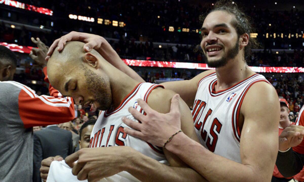 Chicago's Taj Gibson, left, is congratulated by teammate Joakim Noah after hitting a winning shot in overtime to defeat the Lakers, 102-100, on Jan. 20.