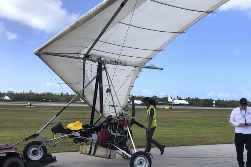 In this photo, provided by the Monroe County Sheriff's Office via the Florida Keys News Bureau, Key West International Airport personnel examine an ultralight aircraft that landed illegally at the airport carrying two Cuban men Saturday, March 25, 2023, in Key West, Fla. An airport spokesperson reported that both men were uninjured and were taken into custody by the Sheriff's Office. There were no interruptions in service and operations continue as normal, airport officials added. (Monroe County Sheriff's Office /the Florida Keys News Bureau via AP)