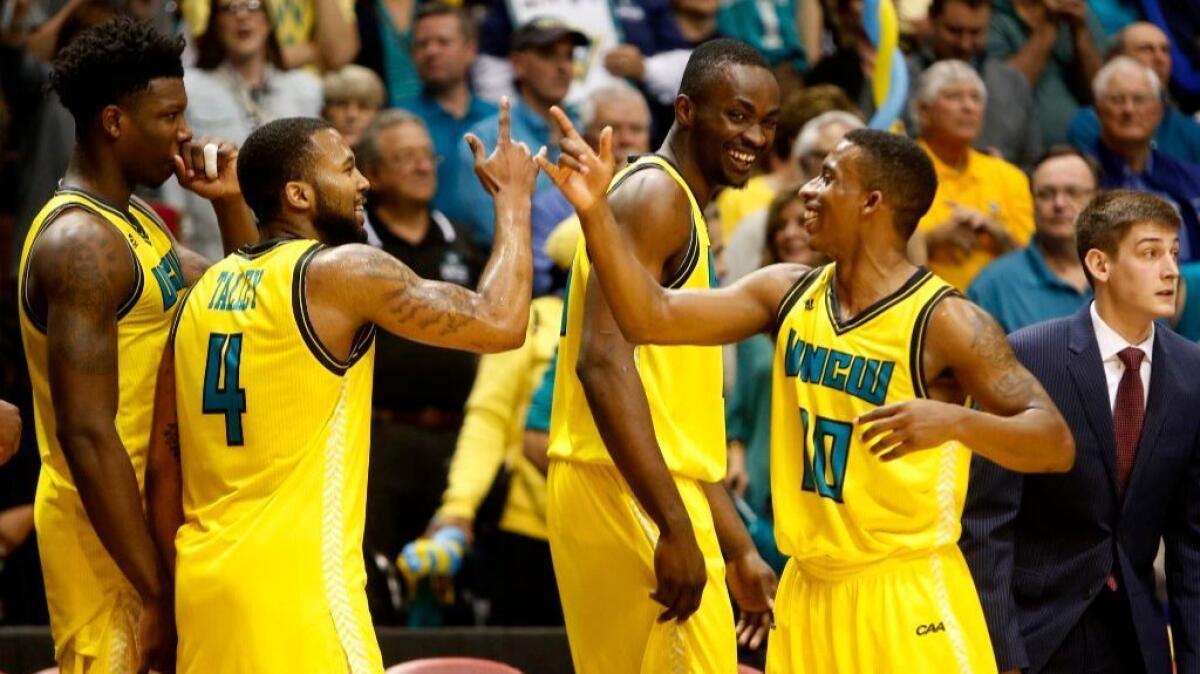 UNC Wilmington players celebrate on the bench after defeating College of Charleston to win the Colonial Athletic Association tournament on Mar. 6.