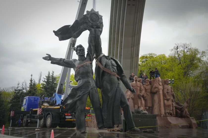 A Soviet era monument to a friendship between Ukrainian and Russian nations is seen during its demolition, amid Russia's invasion of Ukraine, in central Kyiv, Ukraine, Tuesday, April 26, 2022. (AP Photo/Efrem Lukatsky)