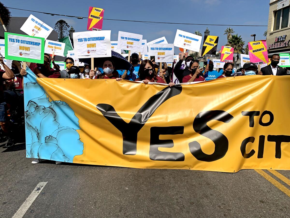 Demonstrators hold "Yes to citizenship" signs at a march