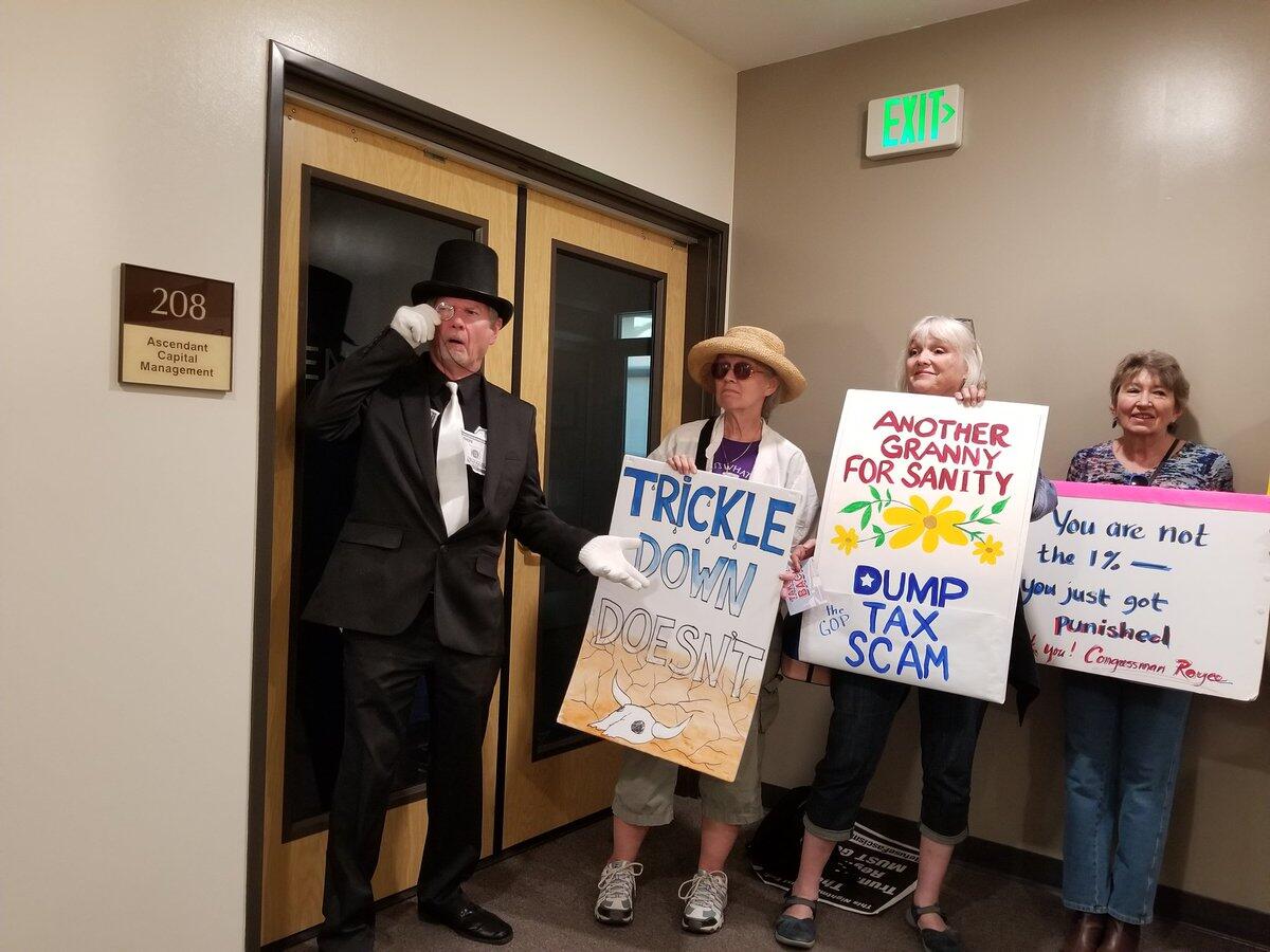 Protesters pose for photos in the hall outside Rep. Ed Royce's district office in Brea.