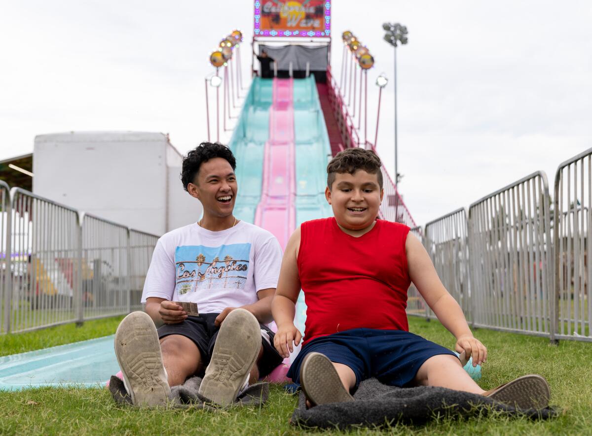 Thien Chau, 18, and Mason Vega, 11, enjoy the California Wave slide during the Original Lobster Festival in Fountain Valley.