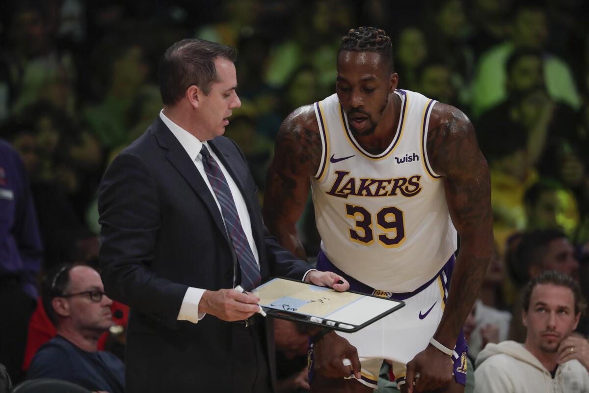 Coach Frank Vogel and veteran center Dwight Howard chat during a break in play during a game earlier this season.