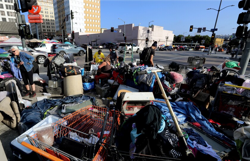 A homeless encampment encroaches on the sidewalk near MacArthur Park