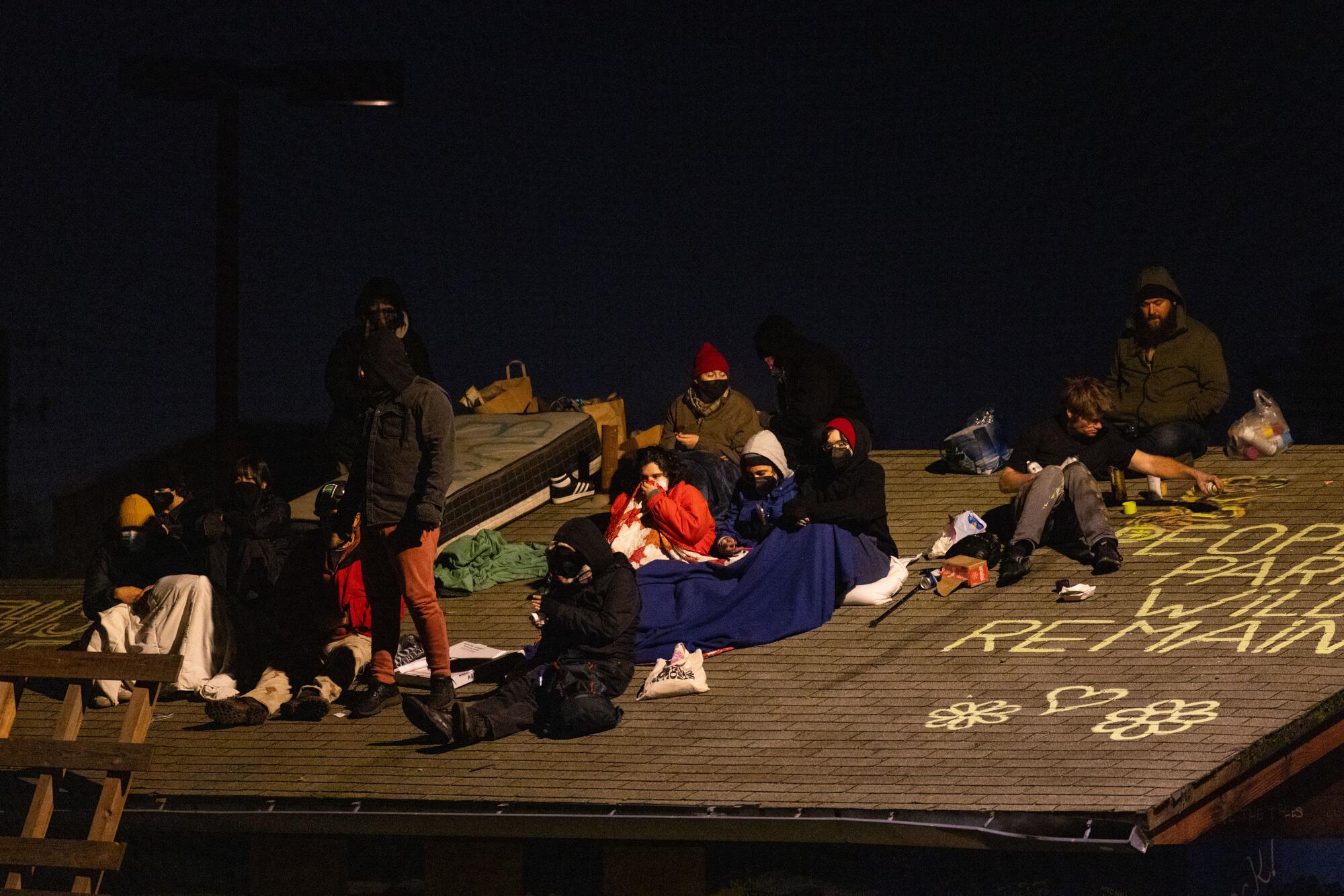Some protesters retreated to the roof of a building in the park before later agreeing to come down.