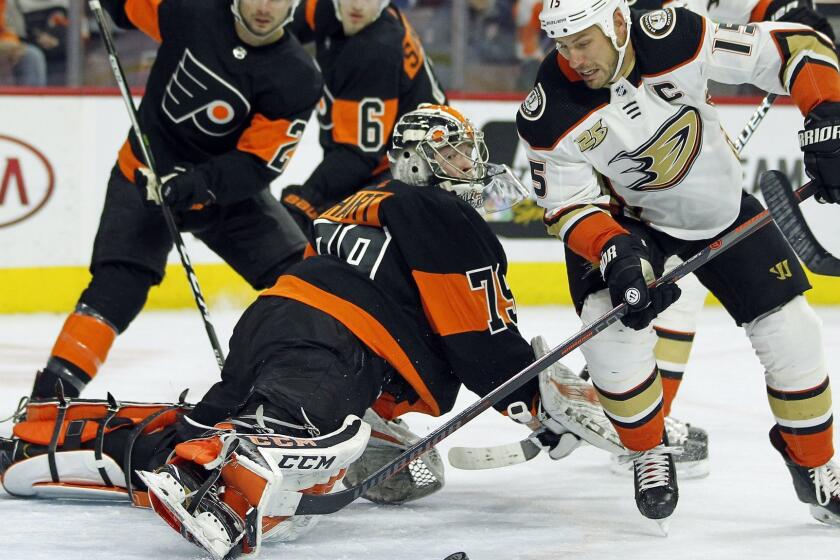 Philadelphia Flyers goalie Carter Hart sticks his leg out to block a scoring attempt by Anaheim Ducks' Ryan Getzal, right, during the first period of an NHL hockey game Saturday, Feb. 9, 2019, in Philadelphia. The Flyers won 6-2. (AP Photo/Tom Mihalek)