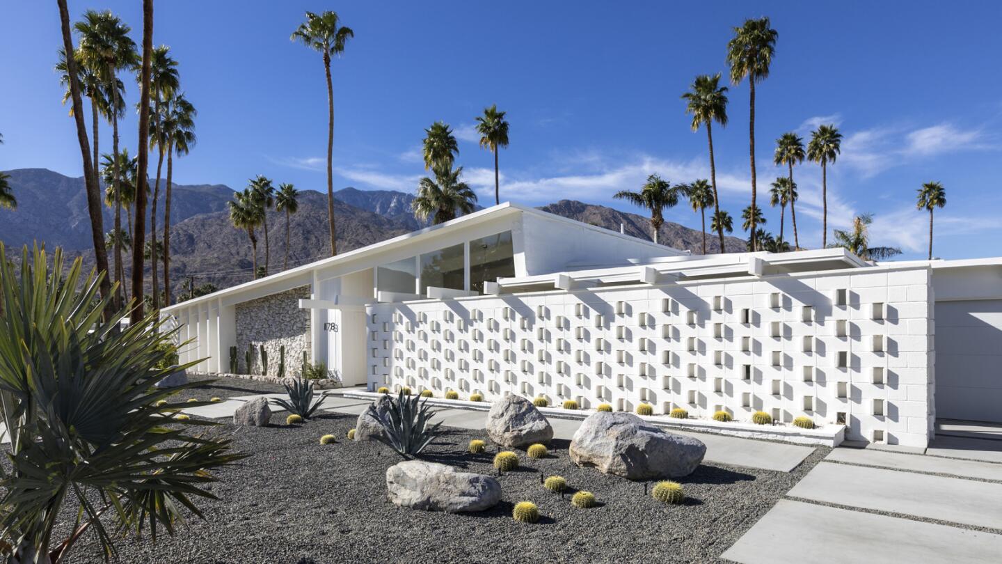 The 1960 midcentury Palm Springs house of Ingrid Jackel's facade features classic midcentury modern decorative concrete blocks and a view of the mountains.