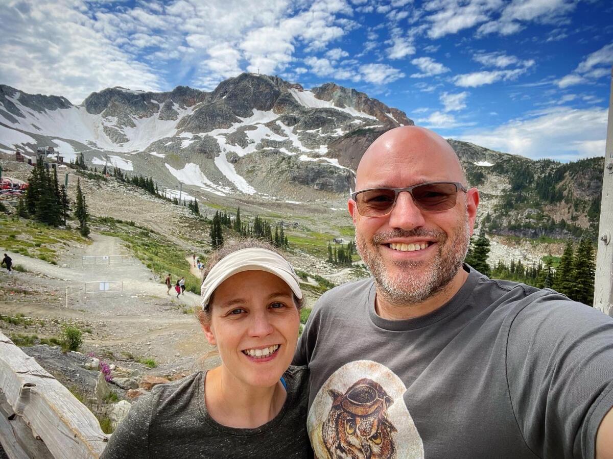 A selfie of a man and woman in front of a mountain landscape