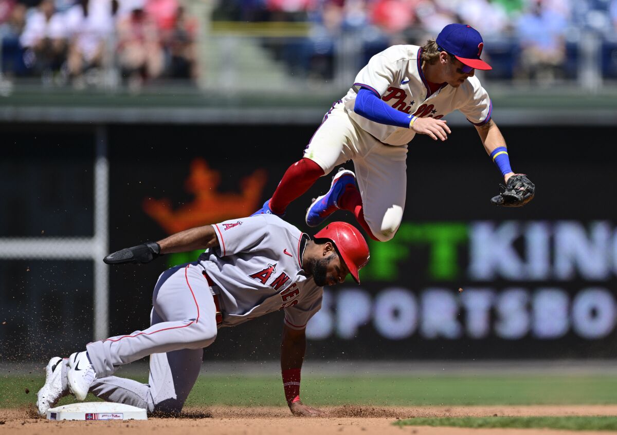Philadelphia's Bryson Stott leaps over the Angels' Jo Adell after a force out at second base.