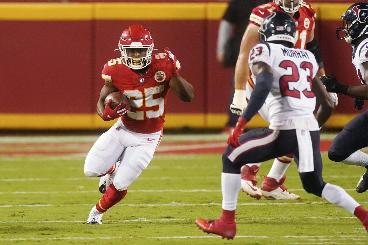 Kansas City Chiefs' Clyde Edwards-Helaire tries to elude Houston Texans' Eric Murray in Thursday's game in Kansas City, Mo.