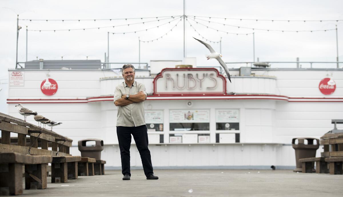 Doug Cavanaugh, founder and chief executive of Ruby's Restaurant Group, poses in front of the original Ruby's at the Balboa Pier. The restaurant is celebrating its 35th anniversary.