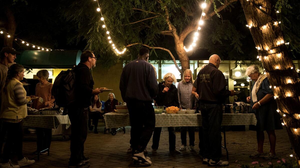 People line up as volunteers serve food at Malibu United Methodist Church. Dinners for homeless put on by the church are ending amid pressure from the city.