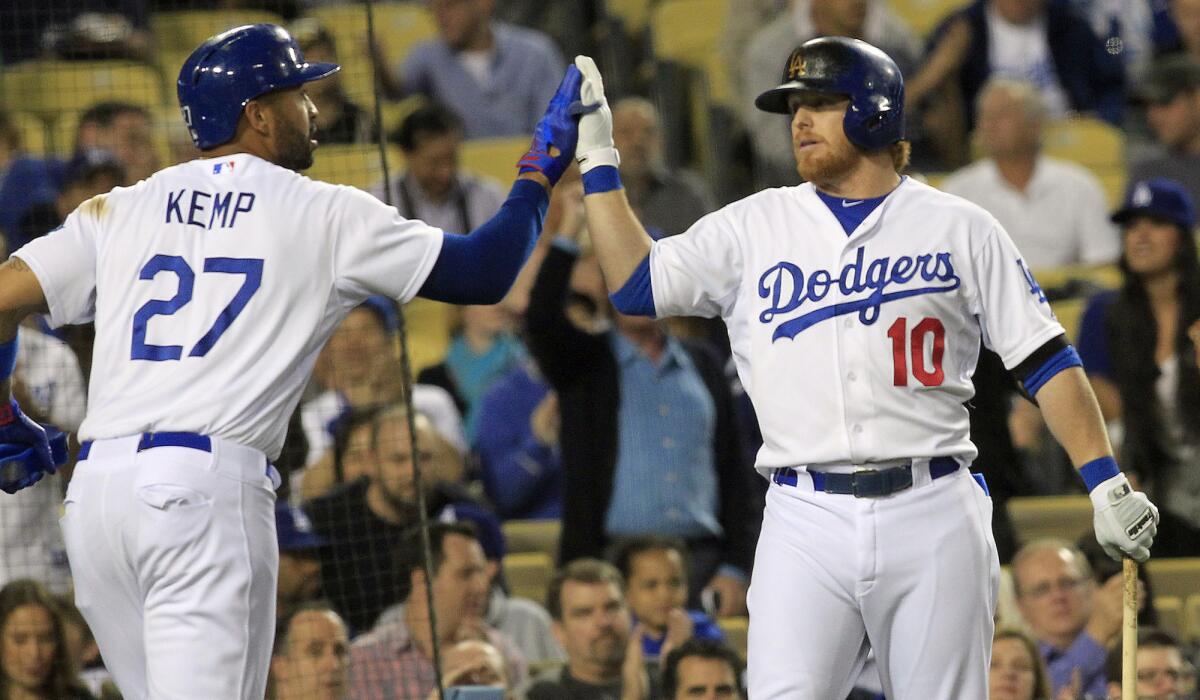 Dodgers center fielder Matt Kemp, left, is congratulated by second baseman Justin Turner after scoring on a sacrifice fly by Juan Uribe (not pictured) during the second inning of the Dodgers' 5-2 win over the Philadelphia Phillies on Wednesday.