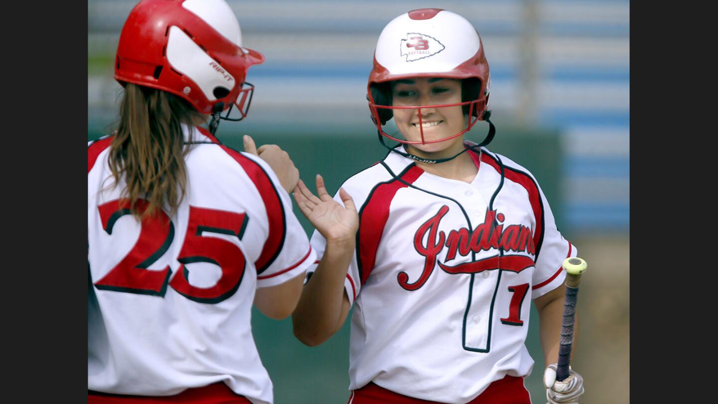 Burroughs High School softball player #1 Amanda Flores gets a high five from #25 Presley Miraglia after Flores scores the first run in game vs. Arcadia High School at home in Burbank on Tuesday, May 9, 2017.