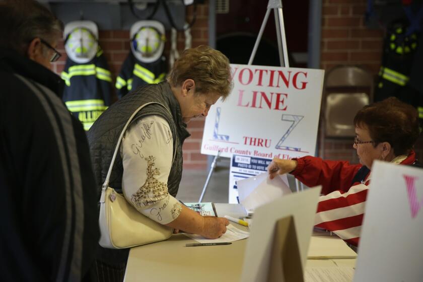 Voters check in Tuesday at a fire station that serves as a polling place in Climax, N.C. Democratic U.S. Sen. Kay Hagan is running in a tight race against Republican state House Speaker Thom Tillis.