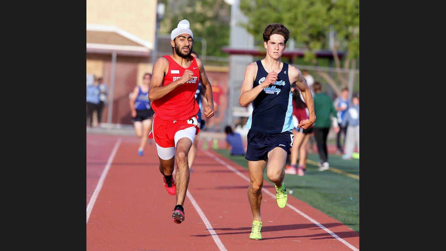 Burroughs' Jagdeep Chahal and Crescenta Valley's Colin FitzGerald sprint side-by-side to the finish in what was called a photo finish in the 1600 in the Pacific League track finals at Arcadia High School on Friday, May 5, 2017. Chahal beat FitzGerald by 0.01 seconds with a time of 4:26.56.