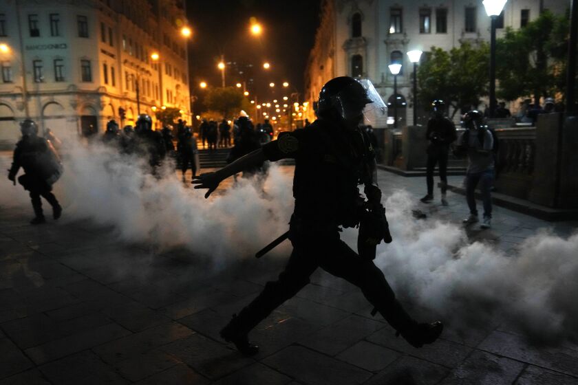Tear gas is returned to police trying to break up supporters of ousted President Pedro Castillo at plaza San Martin in Lima, Peru, Sunday, Dec. 11, 2022. Peru's Congress voted to remove Castillo from office Wednesday and replace him with the vice president, shortly after Castillo tried to dissolve the legislature ahead of a scheduled vote to remove him. (AP Photo/Martin Mejia)