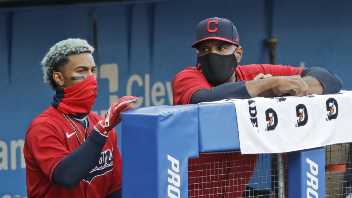Cleveland Indians acting manager Sandy Alomar Jr., right, talks with Francisco Lindor during the first inning in a baseball game against the Cincinnati Reds, Wednesday, Aug. 5, 2020, in Cleveland. (AP Photo/Tony Dejak)