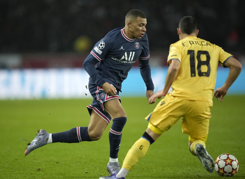 PSG's Kylian Mbappe, left, in action against Brugge's Federico Ricca during the Champions League Group A soccer match between PSG and Club Brugge at the Parc des Princes stadium in Paris, France, Tuesday, Dec. 7, 2021. (AP Photo/Christophe Ena)