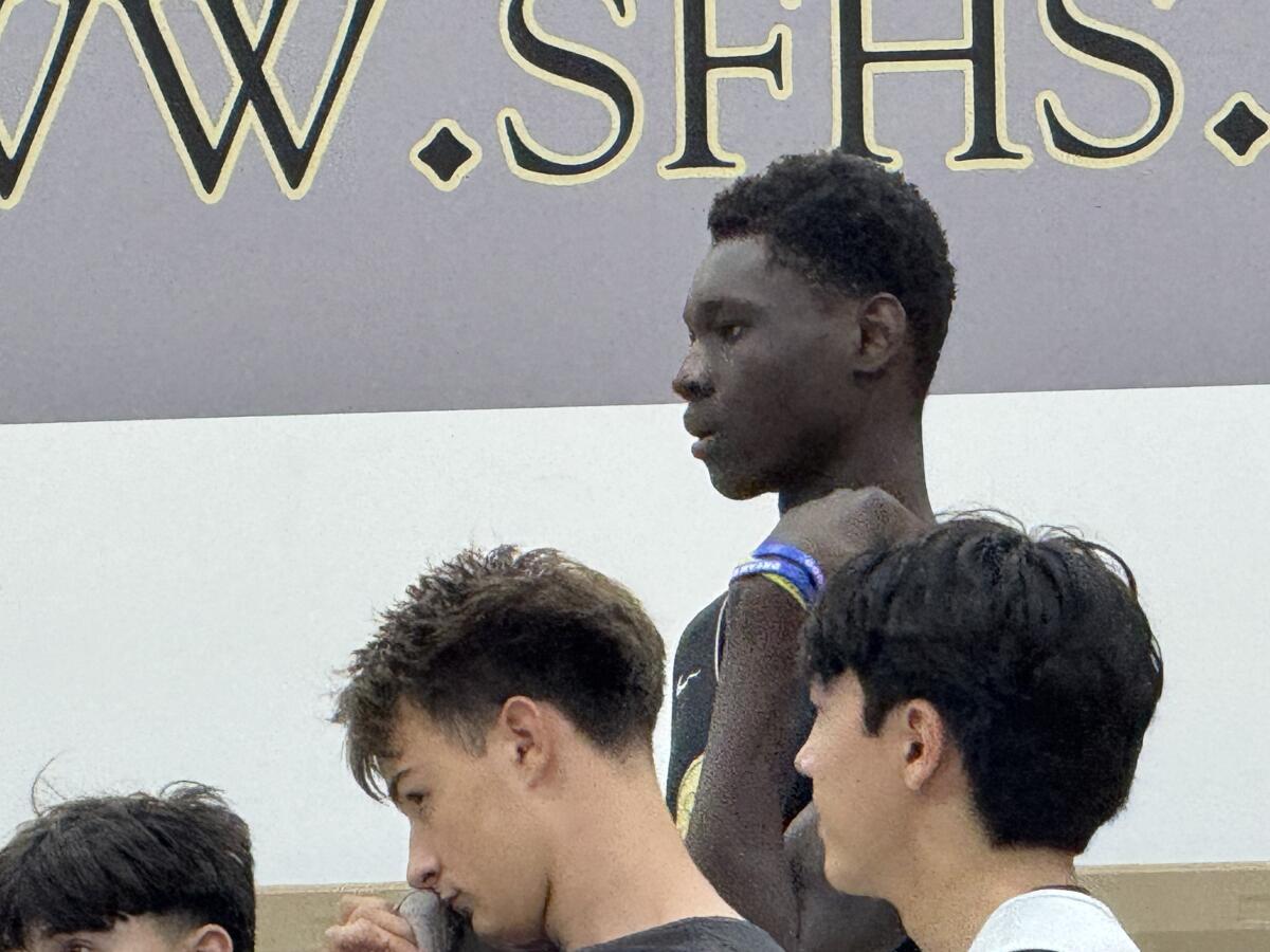 Cherif Millogo towers over his new St. Francis High teammates during a huddle.