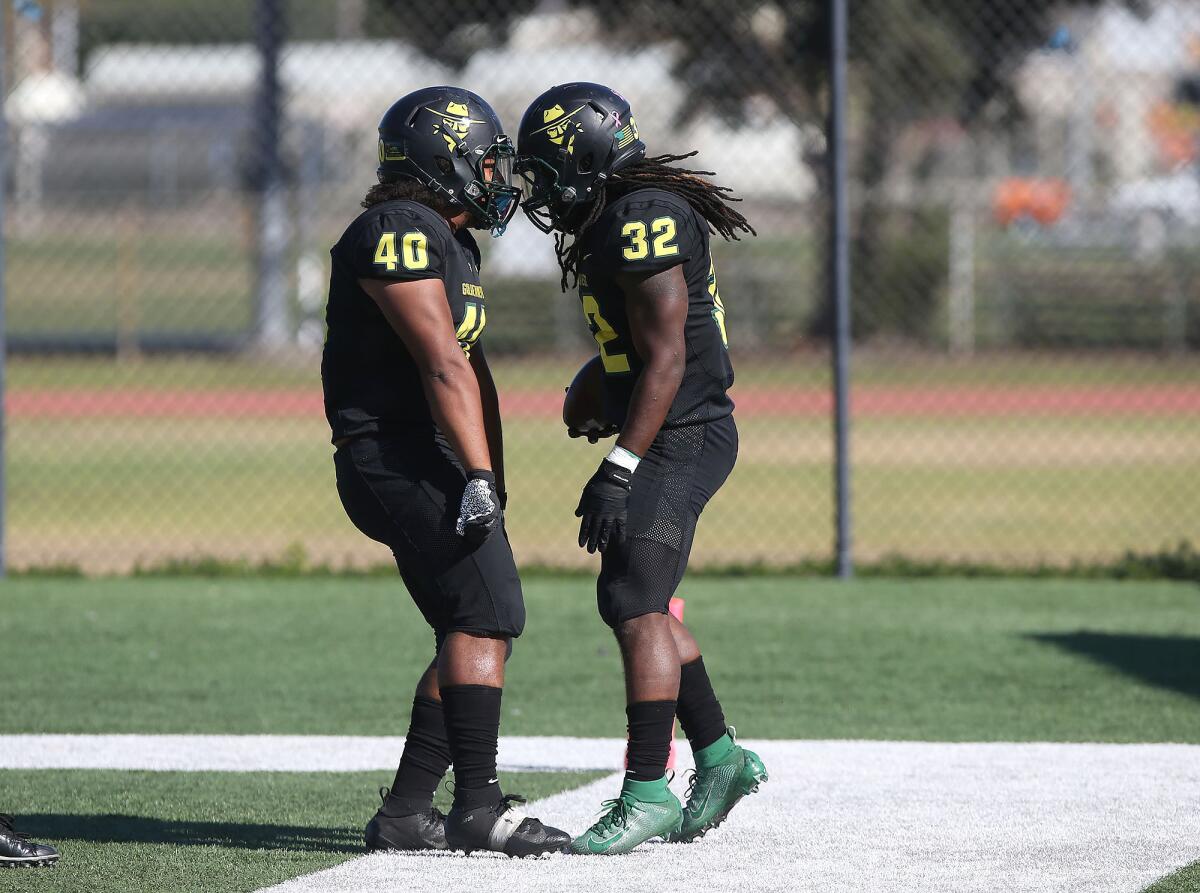 Golden West College running back Tahje Morant (32) celebrates a touchdown with teammate Devon Jackson (40) during a nonconference game against Southwestern on Saturday.