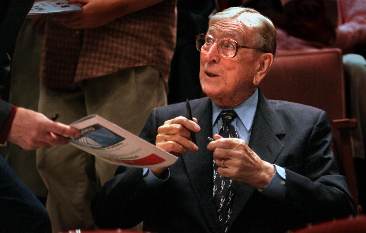 John Wooden signs autographs between games during the Wooden Classic in Anaheim in 1999.