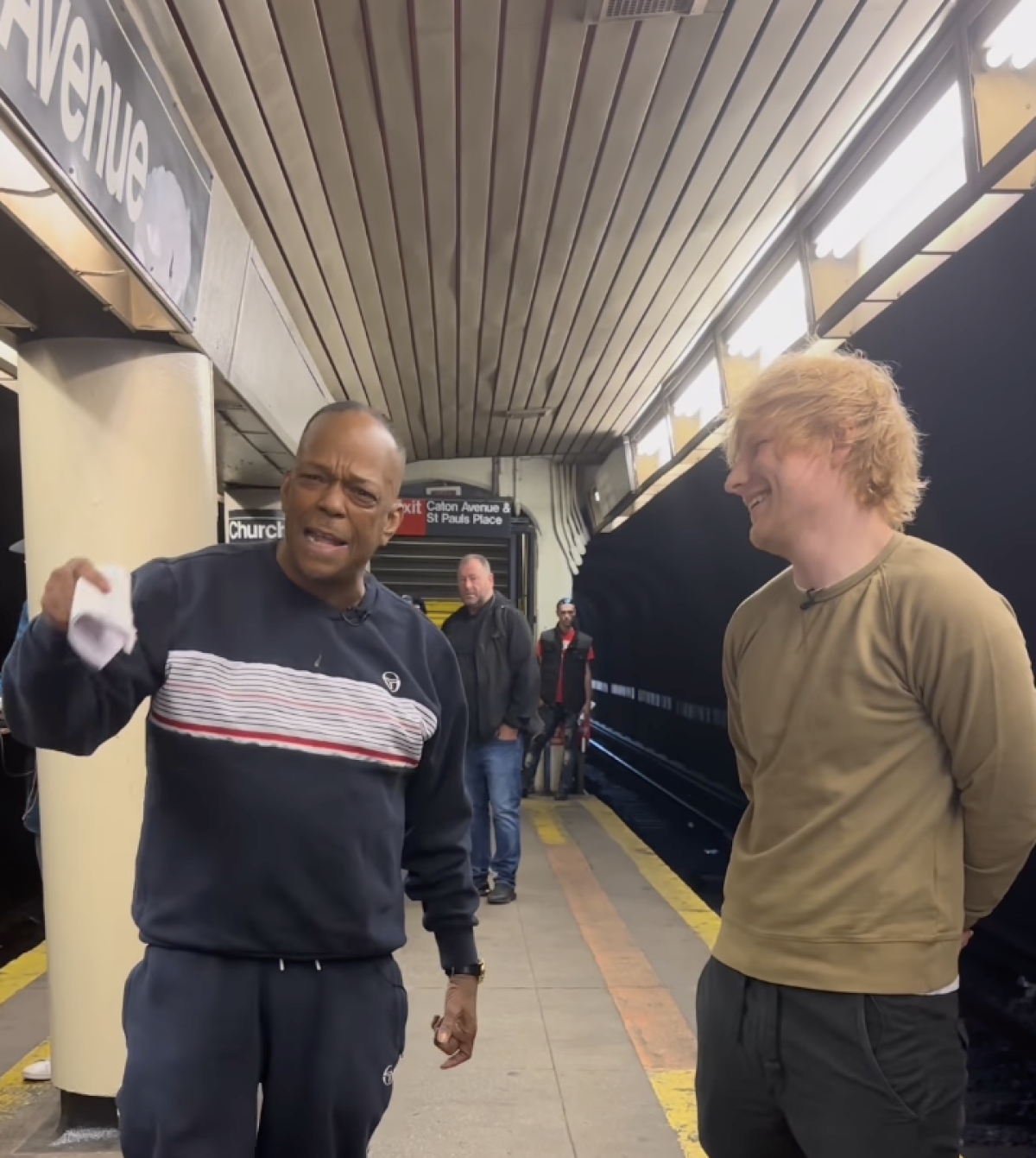On a subway platform, Mike Yung holds a sheet of paper with lyrics and sings alongside Ed Sheeran