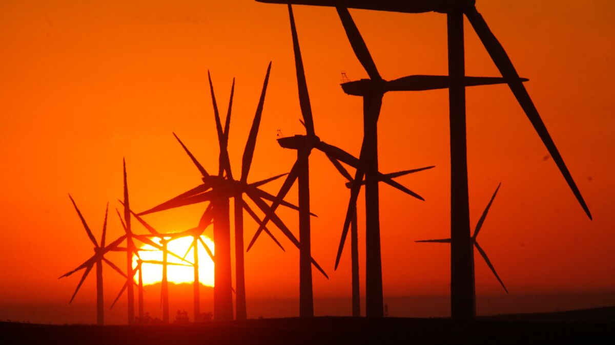 The rising sun silhouettes several giant wind turbines near Rio Vista, Calif., in September 2012.