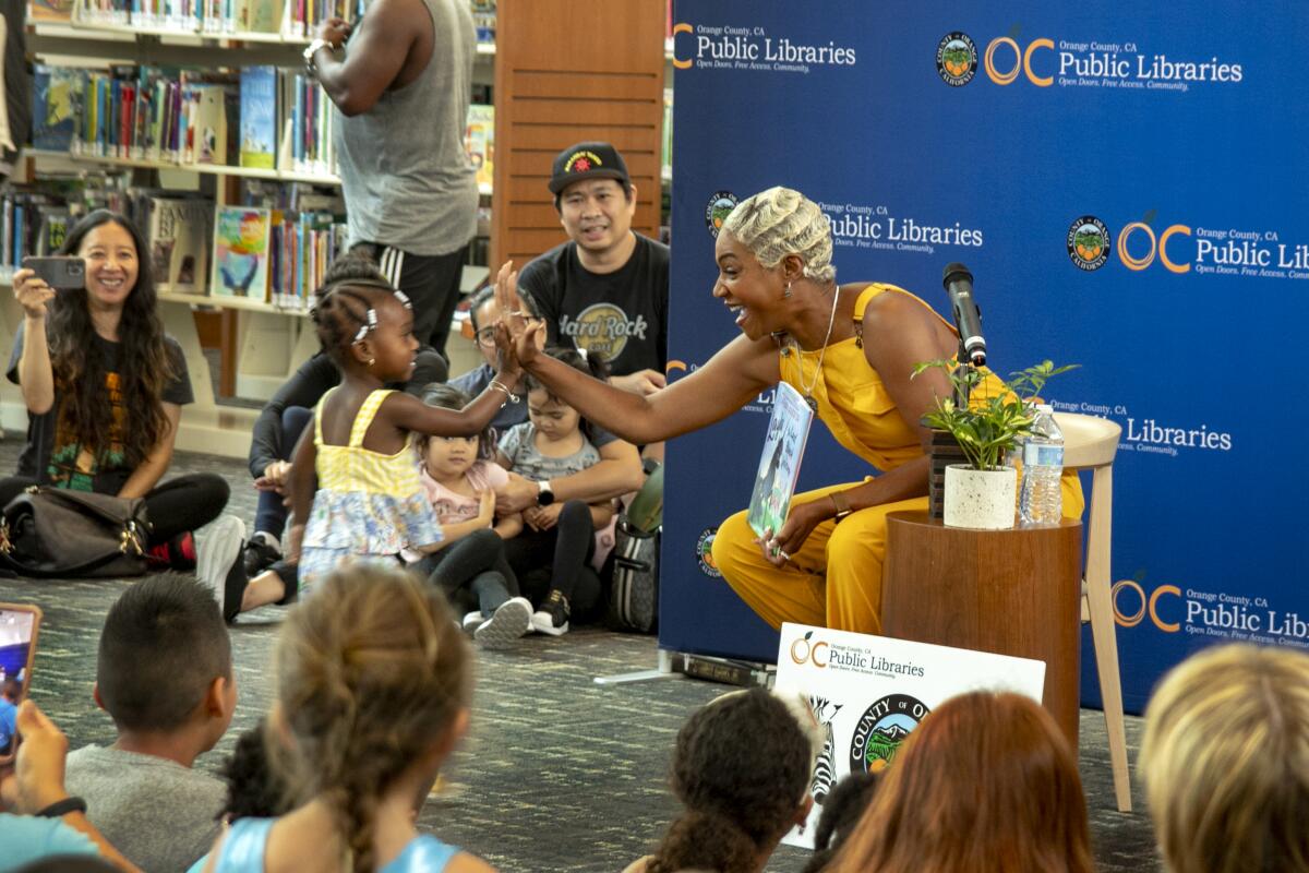 Her reading finished, Tiffany Haddish high-fives a young admirer.