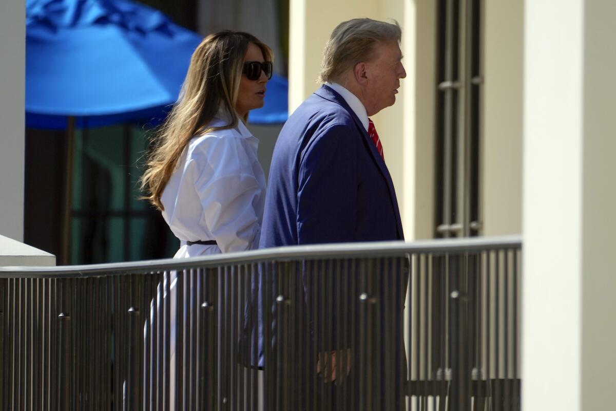 Donald and Melania Trump walk together.