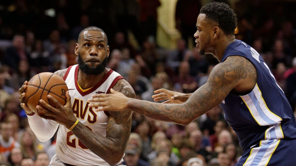 LeBron James drives Memphis Grizzlies' Jarell Martin in the first half.