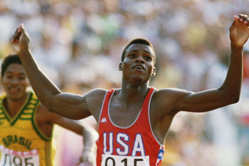 Carl Lewis of the U.S. raises his arms as he wins the 200-meters final during the 1984 Olympic Games at the Coliseum in Los Angeles.